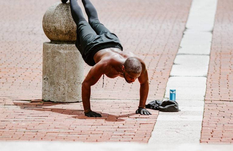 man in black tank top and black shorts lying on brown concrete floor during daytime